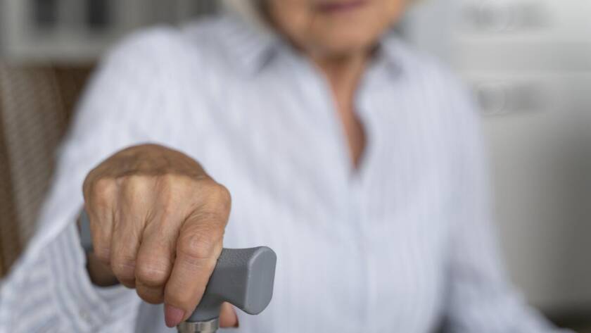 An elderly woman holding a cane
